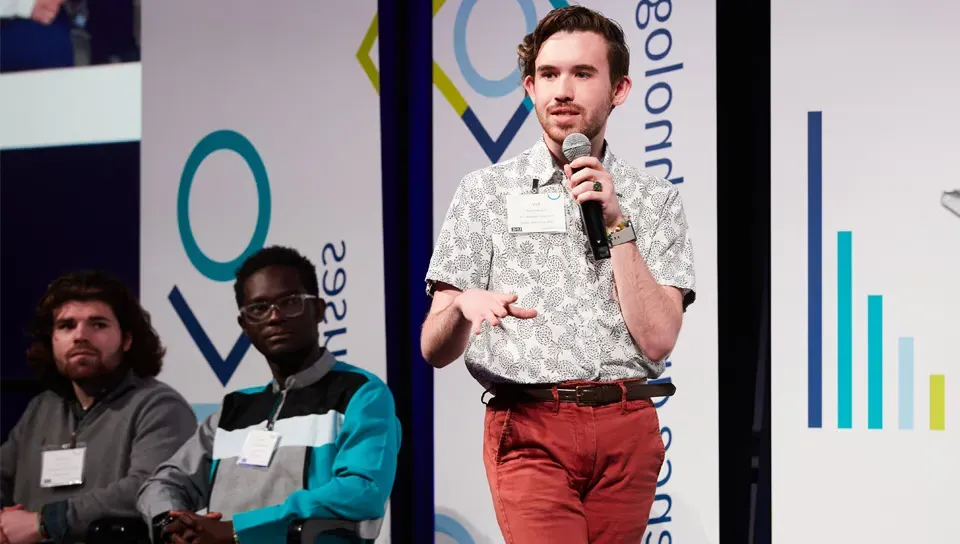 A student speaks on stage at an Innovation Challenge event